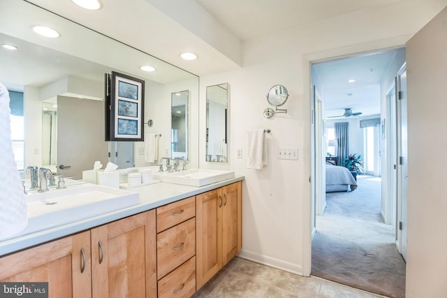 ensuite bathroom with baseboards, double vanity, recessed lighting, and tile patterned floors