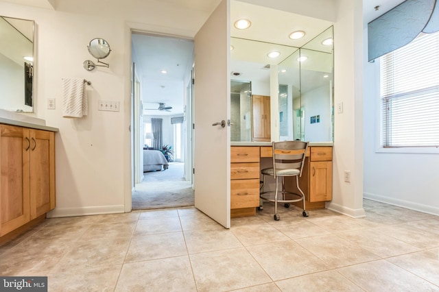 ensuite bathroom featuring tile patterned flooring, vanity, baseboards, and recessed lighting