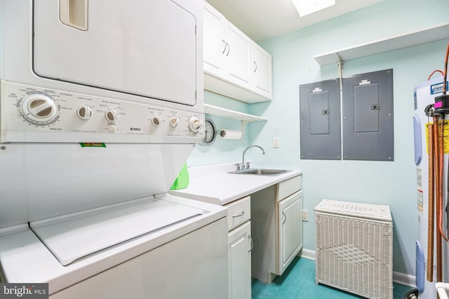 laundry area featuring stacked washer and clothes dryer, electric panel, water heater, and cabinet space