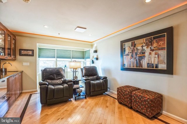living area with light wood-style flooring, baseboards, recessed lighting, and ornamental molding