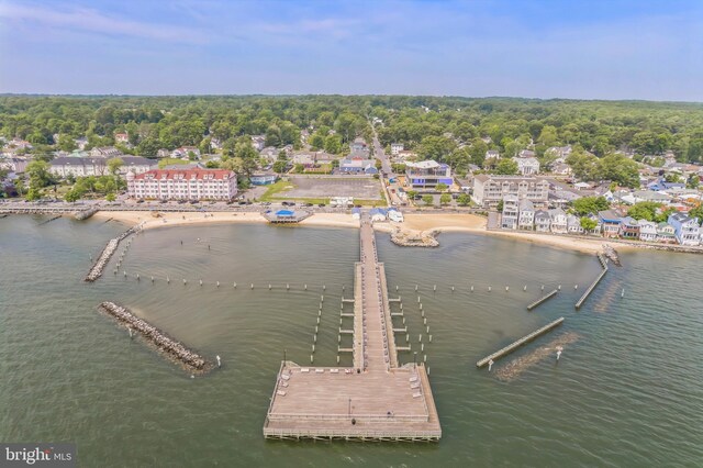 aerial view of property's location featuring a large body of water and a heavily wooded area