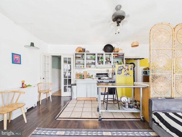 4714 Woodland Ave, Philadelphia, PA 19143 - kitchen with white gas range, freestanding refrigerator, wood finished floors, and french doors