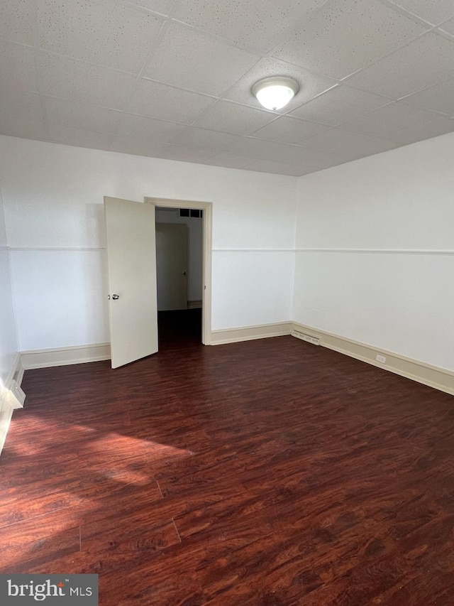 4714 Woodland Ave, Philadelphia, PA 19143 - unfurnished room featuring dark wood-type flooring, baseboards, and a drop ceiling