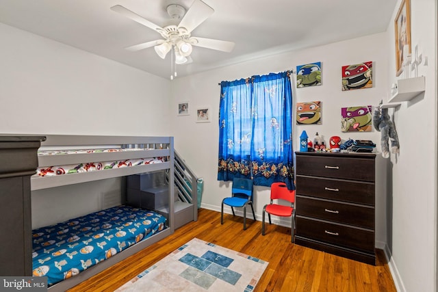 bedroom with wood finished floors, baseboards, and ceiling fan