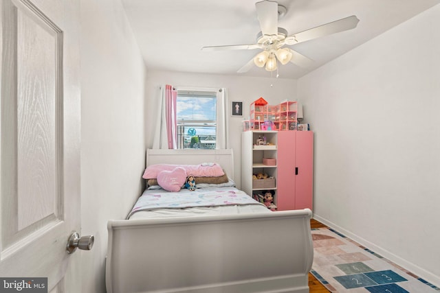 bedroom featuring baseboards, a ceiling fan, and wood finished floors