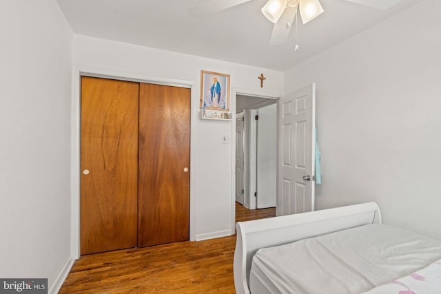 bedroom with wood finished floors, ceiling fan, and a closet