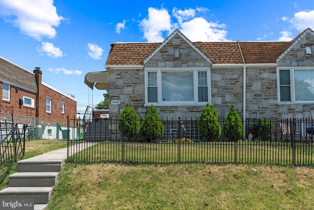 view of front of home with stone siding and roof with shingles