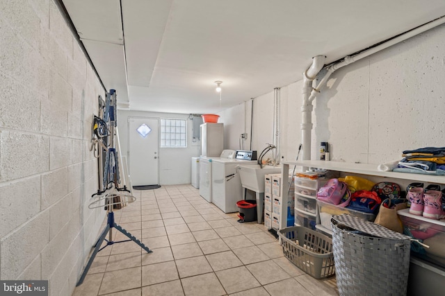 clothes washing area with independent washer and dryer and light tile patterned floors
