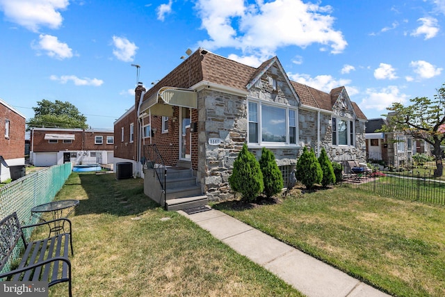 view of home's exterior featuring central AC, stone siding, and a shingled roof