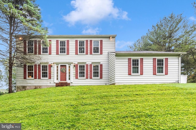 colonial inspired home featuring a front lawn