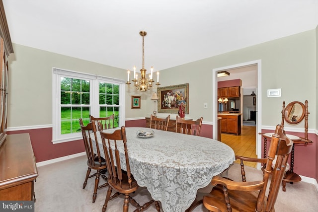 dining area with a chandelier and baseboards