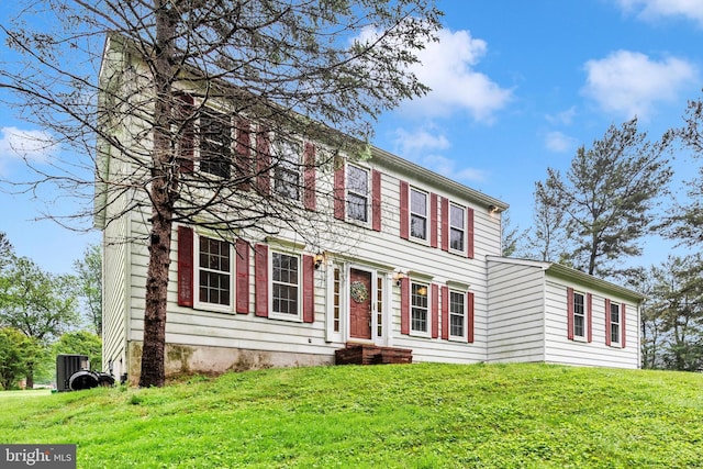 colonial home with a chimney and a front lawn