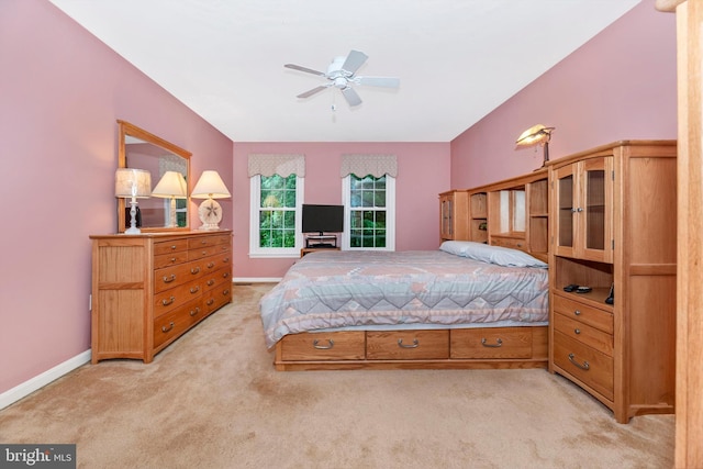 bedroom featuring light carpet, baseboards, and ceiling fan