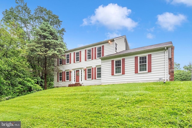 colonial-style house featuring a front lawn