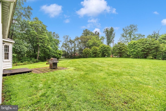 view of grassy yard with a deck