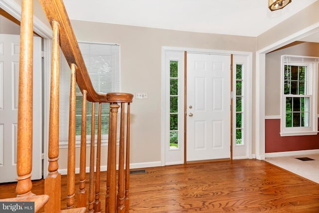 foyer featuring baseboards and wood finished floors