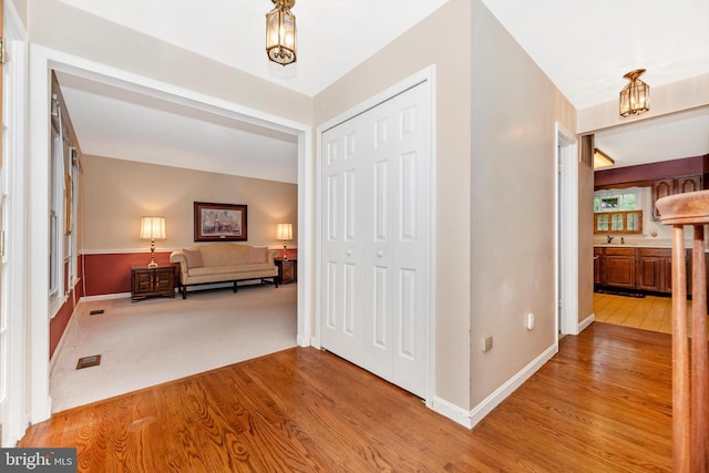 foyer entrance with wood finished floors, baseboards, and a chandelier