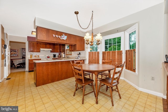 dining area with a chandelier and baseboards