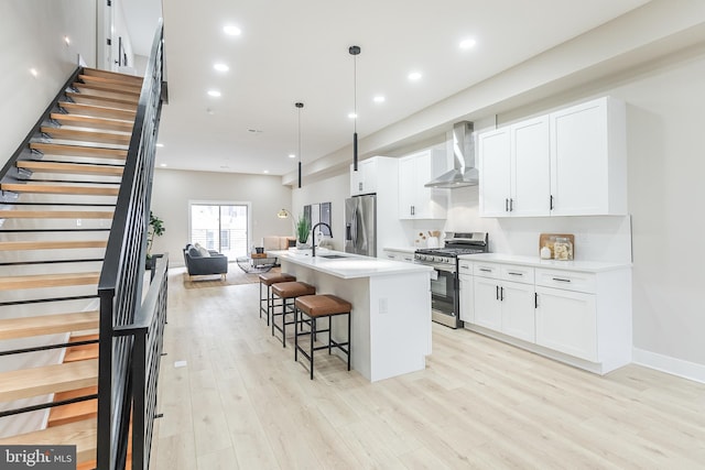 3233 Mercer St, Philadelphia, PA 19134 - kitchen featuring appliances with stainless steel finishes, wall chimney exhaust hood, a sink, a breakfast bar, and a center island with sink