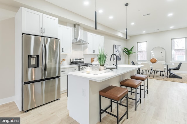 3233 Mercer St, Philadelphia, PA 19134 - kitchen with appliances with stainless steel finishes, wall chimney range hood, a center island with sink, a sink, and light wood-type flooring