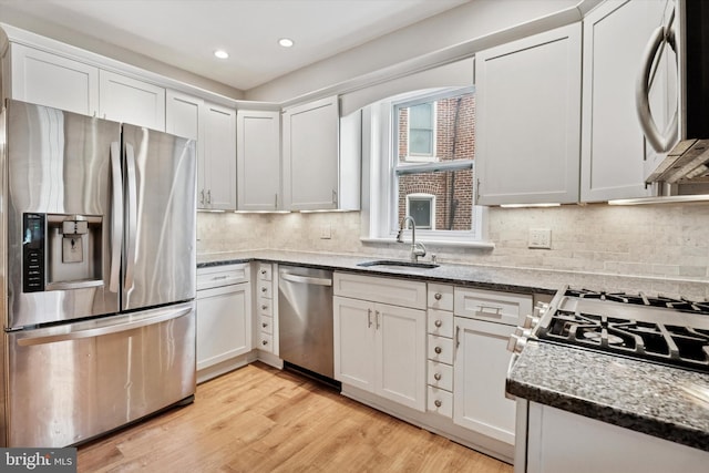 116 N 9th St, Perkasie, PA 18944 - kitchen with appliances with stainless steel finishes, a sink, white cabinets, light wood-style flooring, and stone countertops