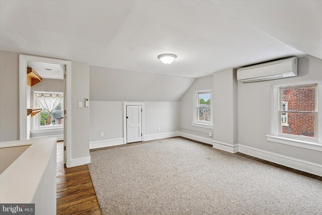116 N 9th St, Perkasie, PA 18944 - bonus room featuring a wall mounted air conditioner, vaulted ceiling, dark wood-style flooring, and baseboards