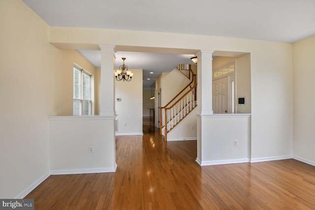 1910 Scaffold Way, Odenton, MD 21113 - spare room featuring decorative columns, wood finished floors, baseboards, a chandelier, and stairs
