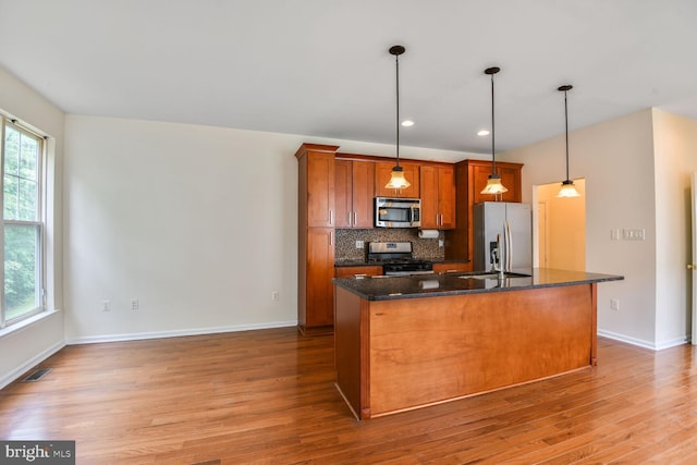 1910 Scaffold Way, Odenton, MD 21113 - kitchen with appliances with stainless steel finishes, wood finished floors, an island with sink, brown cabinets, and decorative backsplash