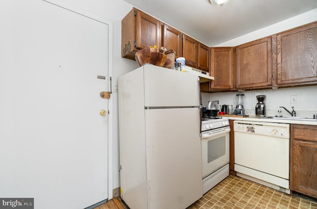 922 24th St NW Unit 313, Washington, DC 20037 - kitchen featuring white appliances, brown cabinetry, light countertops, and under cabinet range hood