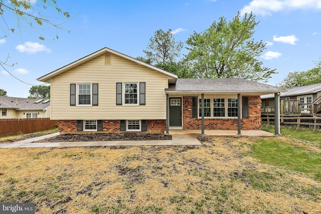 split level home with fence and brick siding