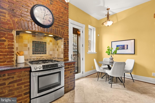 1519 Kingman Pl NW, Washington, DC 20005 - kitchen with stainless steel gas stove, baseboards, pendant lighting, backsplash, and light tile patterned floors