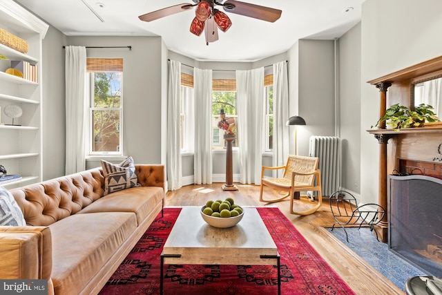1519 Kingman Pl NW, Washington, DC 20005 - living area featuring radiator heating unit, a ceiling fan, wood finished floors, and a premium fireplace