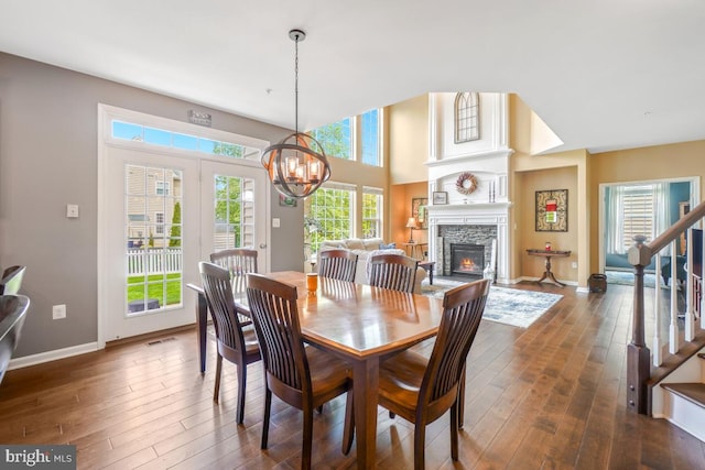 6218 Alan Linton Blvd W, Frederick, MD 21703 - dining room featuring dark wood finished floors, stairway, a chandelier, a stone fireplace, and baseboards