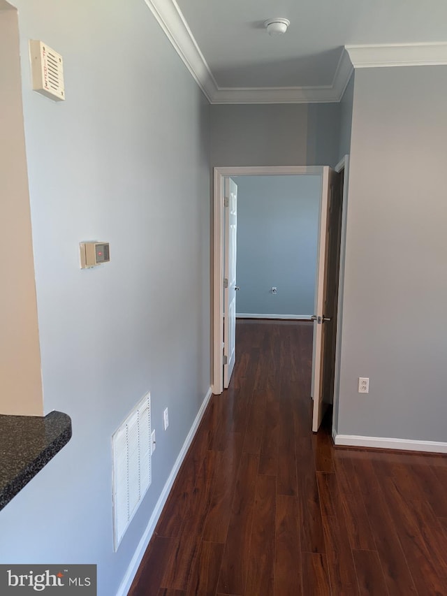 hall featuring crown molding, wood finished floors, and baseboards
