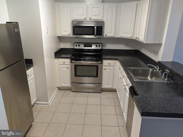 kitchen featuring appliances with stainless steel finishes, a sink, white cabinets, and light tile patterned floors
