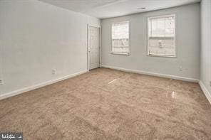 empty room featuring carpet flooring and baseboards