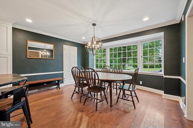 dining space featuring a chandelier, hardwood / wood-style floors, crown molding, baseboards, and recessed lighting