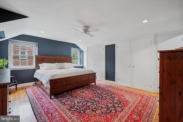 bedroom with vaulted ceiling, two closets, light wood-type flooring, ceiling fan, and recessed lighting