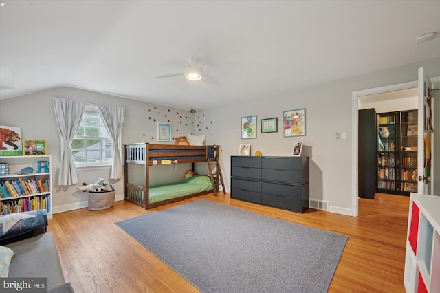 bedroom with light wood-type flooring, ceiling fan, baseboards, and lofted ceiling