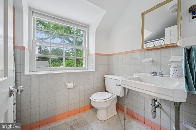 bathroom featuring tile walls, tile patterned floors, toilet, and a wainscoted wall