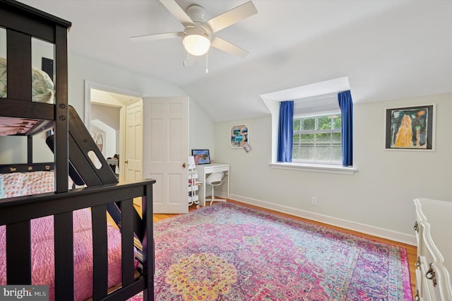 bedroom with wood finished floors, baseboards, vaulted ceiling, and ceiling fan