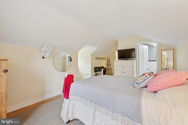 bedroom with baseboards and lofted ceiling