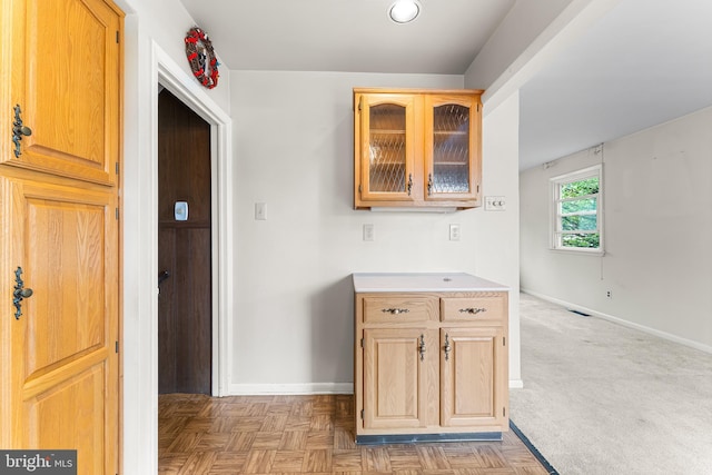kitchen with baseboards, glass insert cabinets, and light countertops