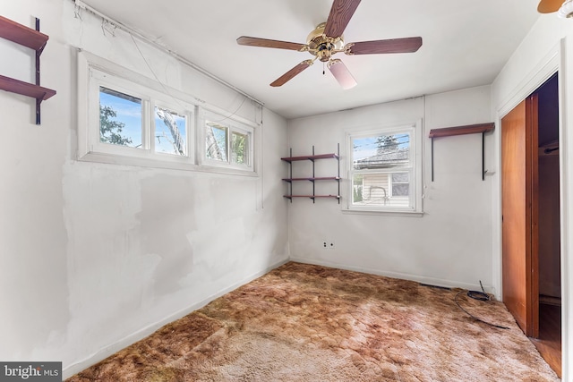 unfurnished bedroom with carpet, a ceiling fan, and baseboards