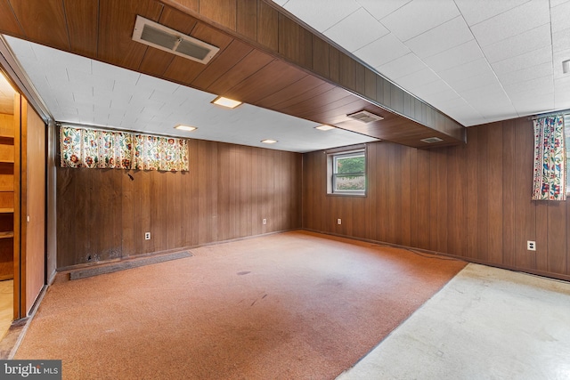 basement with light carpet and wood walls
