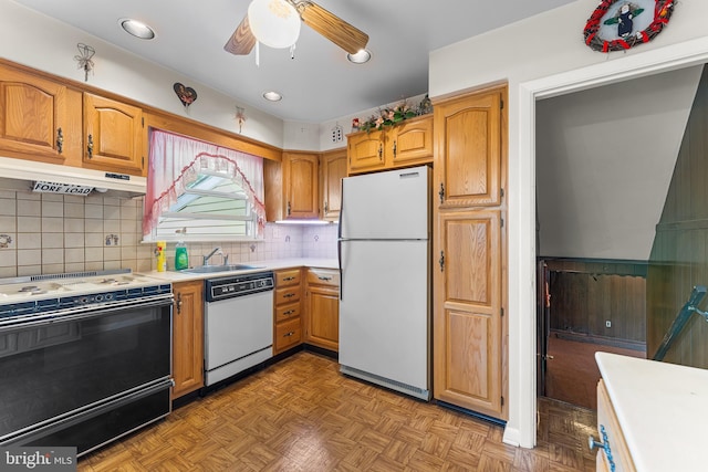 kitchen with white appliances, light countertops, under cabinet range hood, a sink, and ceiling fan
