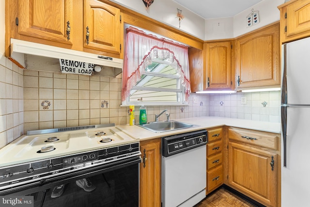 kitchen with white appliances, a sink, under cabinet range hood, light countertops, and backsplash