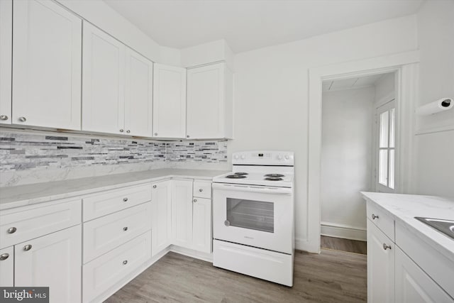 237 Roland Rd, Brookhaven, PA 19015 - kitchen with white electric range, light wood-style flooring, white cabinetry, and backsplash