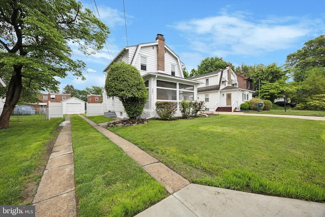 237 Roland Rd, Brookhaven, PA 19015 - view of front facade with a gambrel roof, a sunroom, a chimney, a detached garage, and driveway