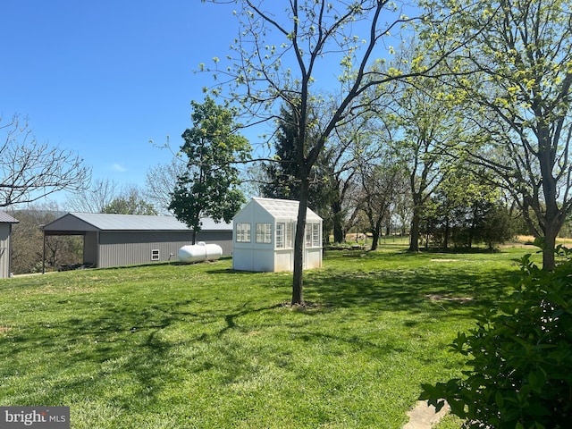 view of grassy yard featuring an outbuilding and a pole building